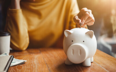 woman hand putting money coin into piggy for saving money wealth